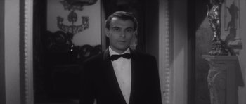 Movie still from “Last Year at Marienbad” (1961), directed by Alain Resnais – A black and white photo of a man in a tuxedo; Close Up shot, High angle