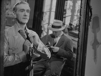 Movie still from “Laura” (1944), directed by Rouben Mamoulian – A man in a suit and a man in a hat and tie; Medium shot, Over the shoulder angle