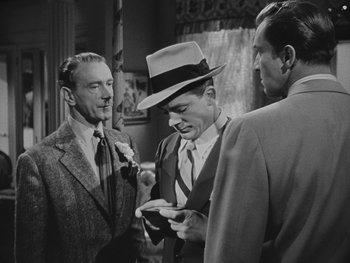 Movie still from “Laura” (1944), directed by Rouben Mamoulian – A group of men standing next to each other in a room; Medium shot, Over the shoulder angle