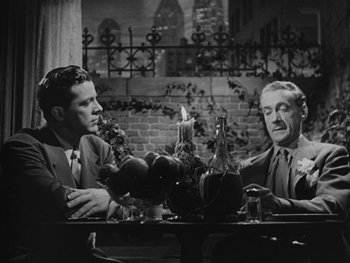 Movie still from “Laura” (1944), directed by Rouben Mamoulian – A couple of men sitting at a dinner table; Medium shot, Low angle