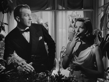 Movie still from “Laura” (1944), directed by Rouben Mamoulian – A black and white photo of a man and a woman smoking; Medium shot, Low angle