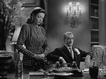 Movie still from “Laura” (1944), directed by Rouben Mamoulian – A man and a woman sitting at a dinner table; Medium shot, Low angle