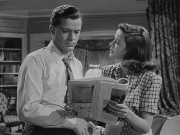 Movie still from “Laura” (1944), directed by Rouben Mamoulian – A man and a woman are looking at a book; Medium shot, High angle