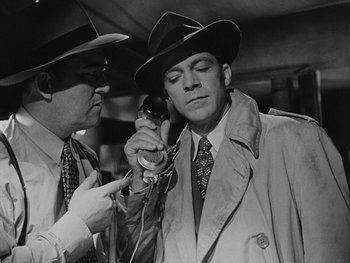 Movie still from “Laura” (1944), directed by Rouben Mamoulian – A man in a hat and a tie is talking on the phone; Medium shot, Low angle