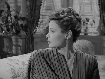Movie still from “Laura” (1944), directed by Rouben Mamoulian – A black - and - white photo of a woman sitting on a couch; Close Up shot, Low angle
