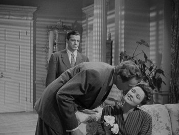 Movie still from “Laura” (1944), directed by Rouben Mamoulian – An old black and white photo of a man kissing a woman; Medium shot, Over the shoulder angle