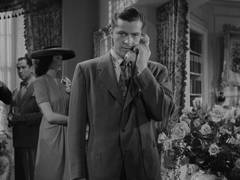 Movie still from “Laura” (1944), directed by Rouben Mamoulian – A black and white photo of a man talking on a phone; Medium shot, Low angle