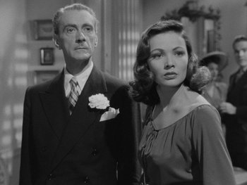 Movie still from “Laura” (1944), directed by Rouben Mamoulian – An older man and a younger woman standing next to each other; Medium shot, Low angle