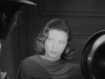 Movie still from “Laura” (1944), directed by Rouben Mamoulian – A black - and - white photo of a woman in a dress; Close Up shot, Over the shoulder angle