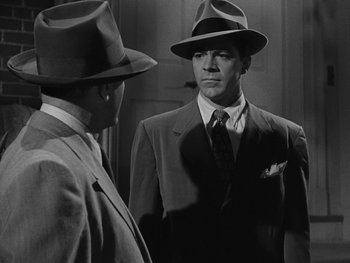 Movie still from “Laura” (1944), directed by Rouben Mamoulian – A man in a suit and a hat standing next to another man in a suit; Medium shot, Over the shoulder angle