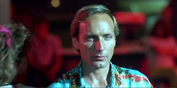 Movie still from “Law of Desire” (1987), directed by Pedro Almodóvar – A person wearing a blue shirt; Close Up shot, Low angle