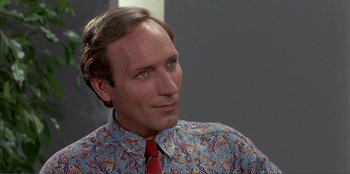 Movie still from “Law of Desire” (1987), directed by Pedro Almodóvar – A person wearing a shirt and a tie; Close Up shot, Over the shoulder angle