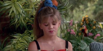 Movie still from “Law of Desire” (1987), directed by Pedro Almodóvar – A young girl with long hair blowing a kiss to the side; Close Up shot, High angle