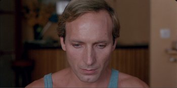 Movie still from “Law of Desire” (1987), directed by Pedro Almodóvar – A person wearing a blue shirt; Close Up shot, Low angle