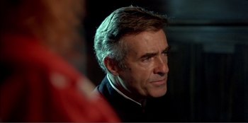 Movie still from “Law of Desire” (1987), directed by Pedro Almodóvar – A person wearing a suit and tie; Close Up shot, Over the shoulder angle