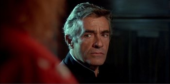 Movie still from “Law of Desire” (1987), directed by Pedro Almodóvar – A person wearing a suit and tie; Close Up shot, Over the shoulder angle