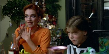 Movie still from “Law of Desire” (1987), directed by Pedro Almodóvar – A woman sitting next to a young girl at a table; Close Up shot, Over the shoulder angle