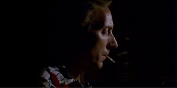 Movie still from “Law of Desire” (1987), directed by Pedro Almodóvar – A person smoking a cigarette; Close Up shot, Low angle