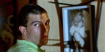 Movie still from “Law of Desire” (1987), directed by Pedro Almodóvar – A person in a room near a mirror; Close Up shot, Over the shoulder angle