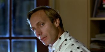 Movie still from “Law of Desire” (1987), directed by Pedro Almodóvar – A person wearing a white shirt with black polka dots; Close Up shot, Low angle