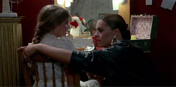 Movie still from “Law of Desire” (1987), directed by Pedro Almodóvar – A woman and a girl are sitting at a dinner table; Medium shot, Over the shoulder angle