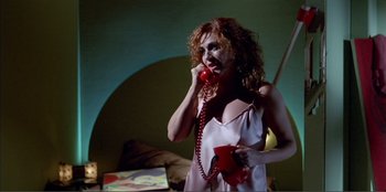 Movie still from “Law of Desire” (1987), directed by Pedro Almodóvar – A woman in a white nightgown talking on a phone; Medium shot, Low angle