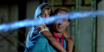 Movie still from “Law of Desire” (1987), directed by Pedro Almodóvar – A man and a little girl are posing for a picture; Medium shot, Low angle