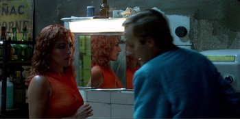 Movie still from “Law of Desire” (1987), directed by Pedro Almodóvar – A man and a woman in front of a bathroom mirror; Medium shot, Over the shoulder angle