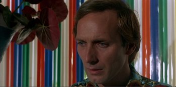 Movie still from “Law of Desire” (1987), directed by Pedro Almodóvar – A person with a flower in front of him; Close Up shot, Low angle