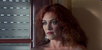 Movie still from “Law of Desire” (1987), directed by Pedro Almodóvar – A person with long red hair; Close Up shot, Low angle