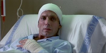 Movie still from “Law of Desire” (1987), directed by Pedro Almodóvar – A man with a bandaged head in a hospital bed; Close Up shot, Overhead angle