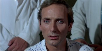 Movie still from “Law of Desire” (1987), directed by Pedro Almodóvar – A person wearing a white shirt; Close Up shot, Over the shoulder angle