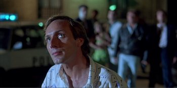 Movie still from “Law of Desire” (1987), directed by Pedro Almodóvar – A man in a white shirt is looking up; Close Up shot, Low angle