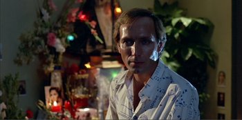 Movie still from “Law of Desire” (1987), directed by Pedro Almodóvar – A man in a white shirt is posing for a picture; Close Up shot, Low angle