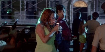 Movie still from “Law of Desire” (1987), directed by Pedro Almodóvar – A man and a woman standing next to each other; Medium shot, Over the shoulder angle