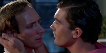 Movie still from “Law of Desire” (1987), directed by Pedro Almodóvar – Two men looking into each other's eyes; Close Up shot, Over the shoulder angle