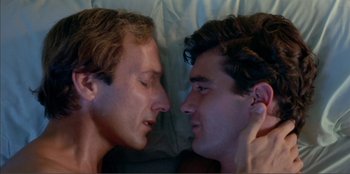 Movie still from “Law of Desire” (1987), directed by Pedro Almodóvar – Two young men laying side by side in a bed; Close Up shot, Overhead angle