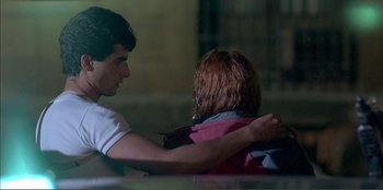 Movie still from “Law of Desire” (1987), directed by Pedro Almodóvar – A man and a woman sitting next to each other; Medium shot, Over the shoulder angle