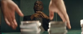 Movie still from “Layer Cake” (2004), directed by Matthew Vaughn – A man sitting in front of a mirror looking at himself in the mirror; Close Up shot, Low angle