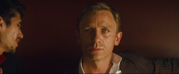 Movie still from “Layer Cake” (2004), directed by Matthew Vaughn – A person wearing a suit and tie; Close Up shot, Over the shoulder angle