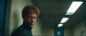 Movie still from “Layer Cake” (2004), directed by Matthew Vaughn – A person with curly hair; Close Up shot, Low angle