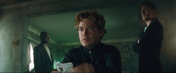 Movie still from “Layer Cake” (2004), directed by Matthew Vaughn – A person holding a newspaper; Close Up shot, Low angle