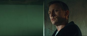 Movie still from “Layer Cake” (2004), directed by Matthew Vaughn – A person looking at the camera; Close Up shot, Low angle