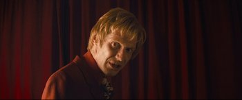 Movie still from “Layer Cake” (2004), directed by Matthew Vaughn – A person wearing a suit and tie; Close Up shot, Low angle