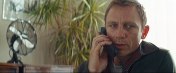 Movie still from “Layer Cake” (2004), directed by Matthew Vaughn – A person talking on a cell phone; Close Up shot, High angle