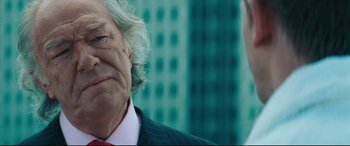 Movie still from “Layer Cake” (2004), directed by Matthew Vaughn – An older man in a business suit and a younger man in a business suit; Close Up shot, Over the shoulder angle