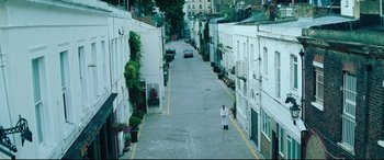 Movie still from “Layer Cake” (2004), directed by Matthew Vaughn – A man standing on the side of a street; Extreme Wide shot, High angle