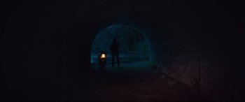 Movie still from “Layer Cake” (2004), directed by Matthew Vaughn – A man standing in a dark tunnel with a motorcycle; Wide shot, Low angle