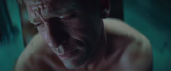 Movie still from “Layer Cake” (2004), directed by Matthew Vaughn – A man's face in the dark; Extreme Close Up shot, Low angle