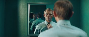 Movie still from “Layer Cake” (2004), directed by Matthew Vaughn – A man looking at himself in the mirror while putting on a tie; Close Up shot, Over the shoulder angle